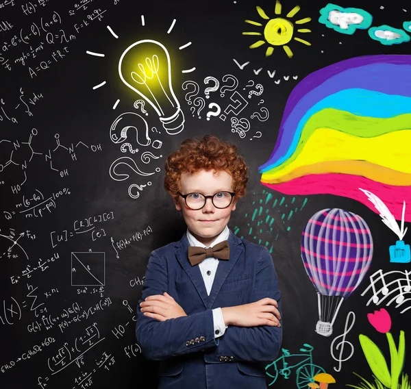 Enfant garçon intelligent avec des cheveux roux, des lunettes et des bras croisés — Photo