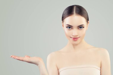 Güzel kadın gülümseyen ve açık el boş kopya alanı gösteren