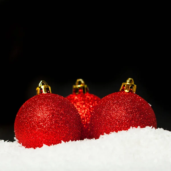 白い雪の上に赤いボーブルとクリスマスブラックカード — ストック写真