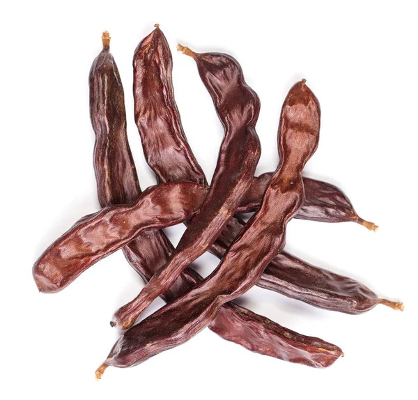 Carob bönor uppifrån. Friska organiska Sweet Carob Pods på vit — Stockfoto