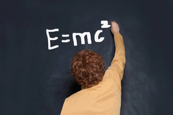 Детский мальчик студент написания формулы науки на школьной доске фон — стоковое фото