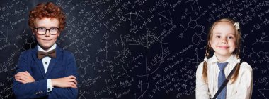 Akıllı çocuk portresi. Kara tahtaya karşı küçük kız ve erkek öğrenci