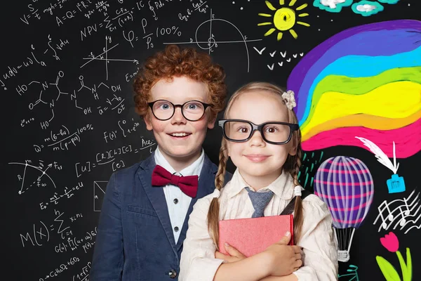 Pequeño chico y chica inteligente en el fondo pizarra con la ciencia — Foto de Stock