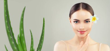 Aloe yaprağı ve tropik çiçeği olan kadın, spa ve cilt bakımı konsepti