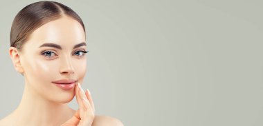 Açık tenli, gülümseyen genç bir model kadın.