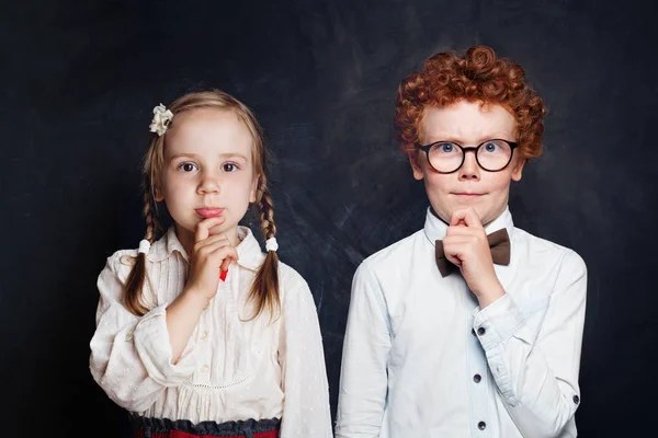 Twee denkende kinderen op schoolbord portret — Stockfoto