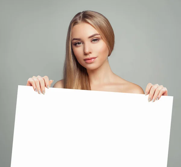 Νεαρή γυναίκα μοντέλο με διαυγές δέρμα που κρατά κενή λευκή κάρτα singboard — Φωτογραφία Αρχείου
