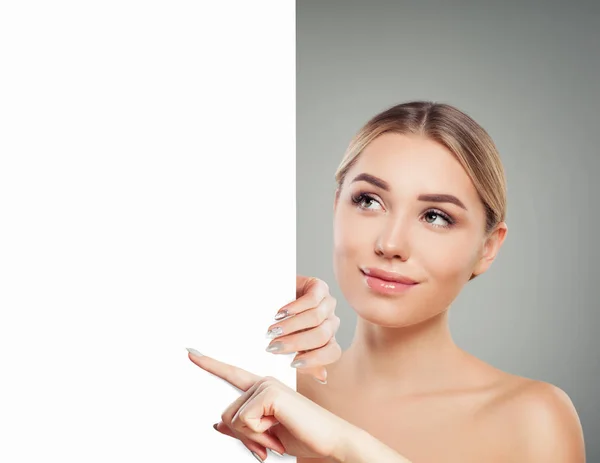 Mujer alegre con la piel clara que muestra la tarjeta blanca vacía singboard — Foto de Stock