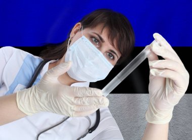 Test tüpü Coronavirus veya Estonya bayrağına karşı COVID-19 olan bilim kadını. Estonya 'daki bir salgının önlenmesi için laboratuvarda virüslerin araştırılması