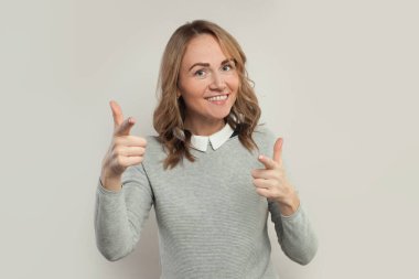 Mutlu kadın gülümsüyor ve beyaz arka planda işaret ediyor