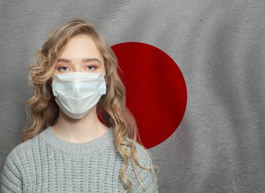 Ulusal Japon bayrağıyla yüz maskesi takan genç bir kadın. Grip salgını ve virüs koruma kavramı