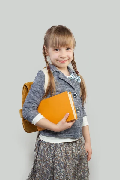 スクールバッグと本を持つ陽気な子供の女の子 学校のコンセプトに戻る — ストック写真
