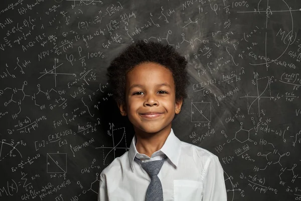 科学と数学の公式と黒板の背景に幸せなスマート黒の子供の学生 — ストック写真