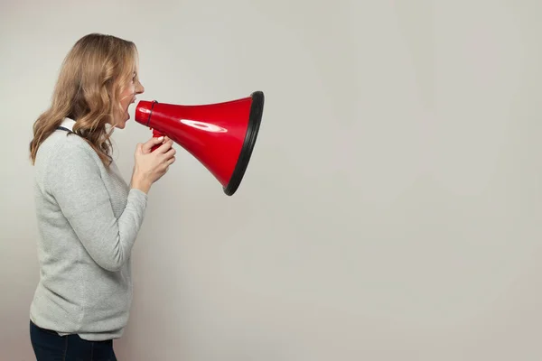 真正的女人尖叫着用喇叭扩音器 拿着红色牛角的女孩 — 图库照片