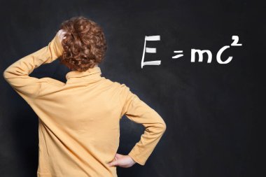 Tahta arka planda çocuk ve bilim formülü düşünüyorum.