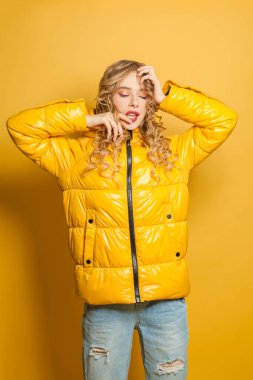 Parlak sarı arka planda sarı ceketli mükemmel kadının moda portresi.