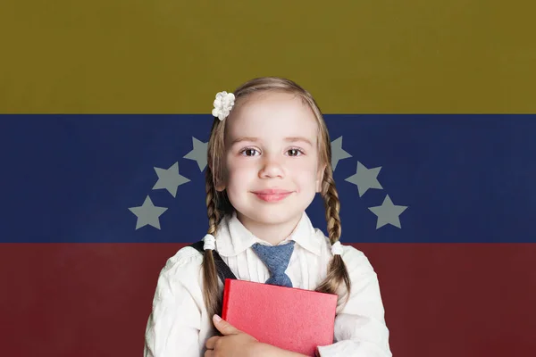 Learning spainish language. Smart child girl on the spain flag background