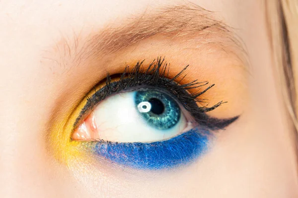 Frauenauge Schaut Auf Blauer Und Gelber Lidschatten Und Schwarzer Eyeliner — Stockfoto