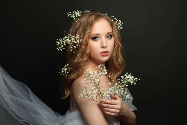 黒の背景に長い健康的な巻き毛と白い花を持つ婚約者の女の子 — ストック写真