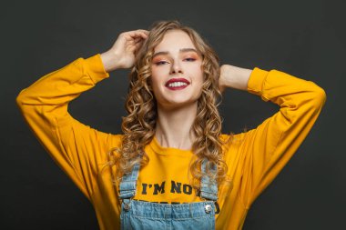 Siyah arka planda gülümseyen neşeli kadın.