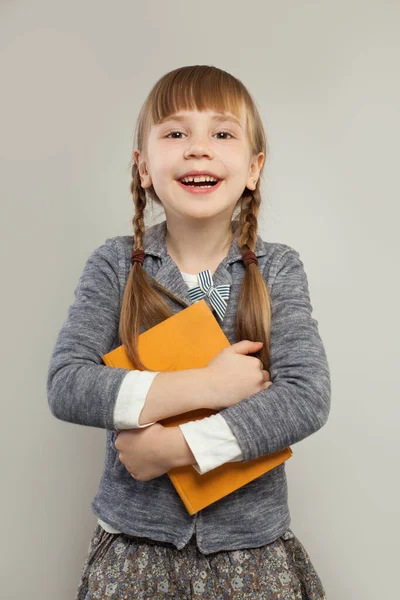 Feliz Niña Sosteniendo Libro Riendo Pie Sobre Fondo Blanco —  Fotos de Stock