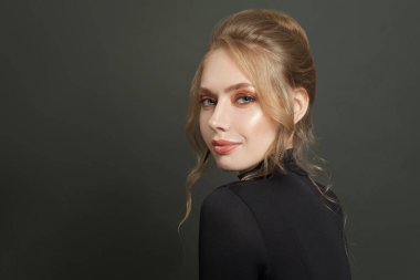 Siyah balıkçı yakalı güzel kadın gülümsüyor.