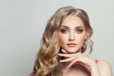 Uzun sarı kıvırcık saçlı, beyaz saçlı hoş bir kadın.