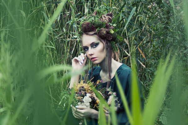 Beautiful fairy woman in green grass outdoors