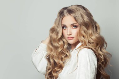 Uzun, sağlıklı kıvırcık saçlı güzel sarışın kadın.