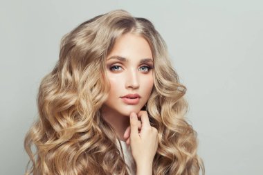 Uzun, sağlıklı kıvırcık saçlı hoş sarışın kadın.