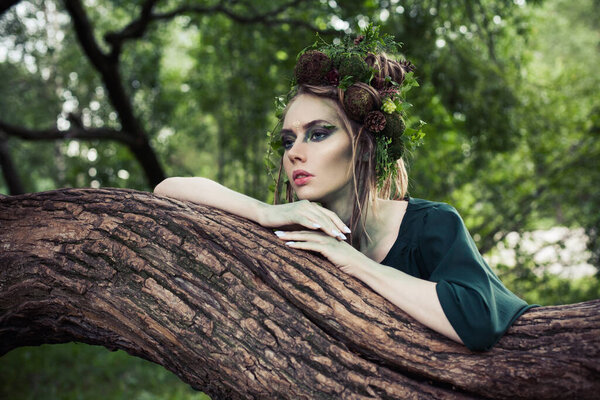 Beautiful woman with perfect creative hairstyle in forest. Halloween character or Forest soul