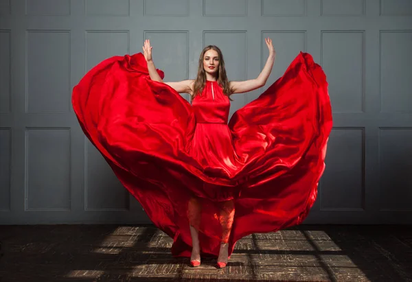 Mujer Feliz Soplado Vestido Sedoso Rojo Posando Interior — Foto de Stock