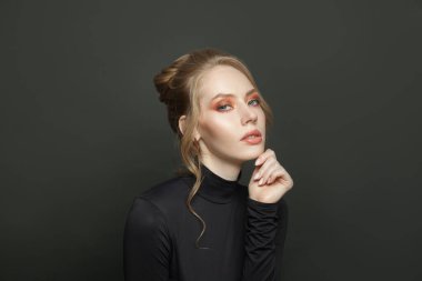 Siyah arka planda çekici bir genç kadın, portre.