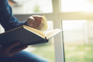 Kitap okuma sandalyede oturan adamın kısmi görünümü