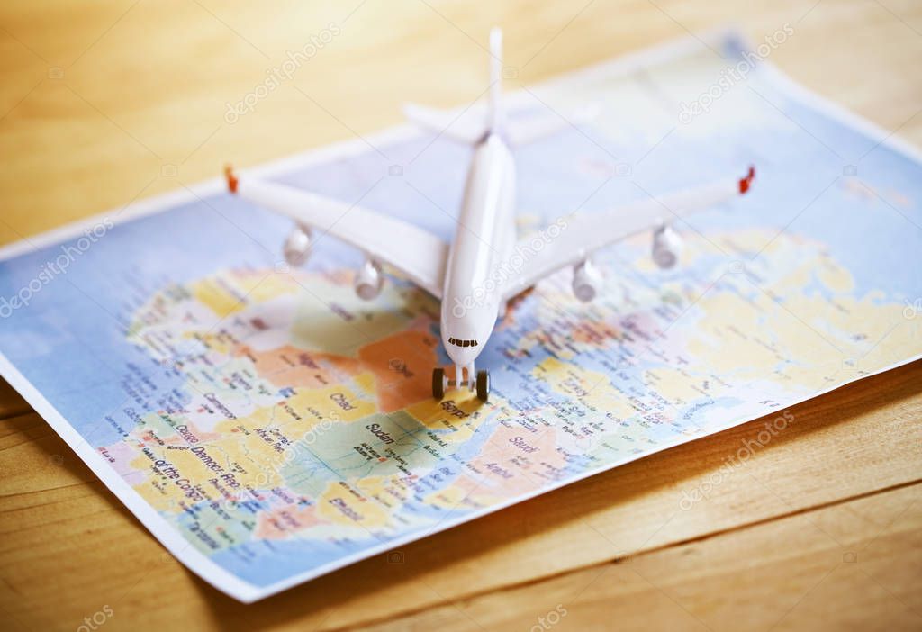 Plane model with world map as airplane traveling concept