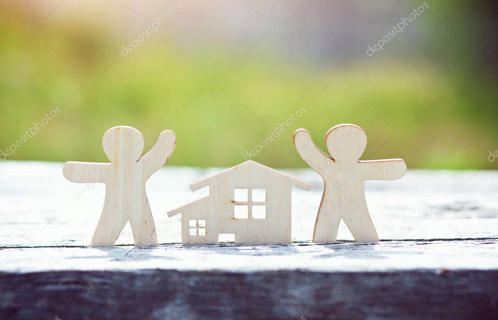 little wooden men and house on natural background