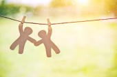 Dřevěné malí mužíčci visí na laně s pin. Symbol přátelství, pomoc, podpora a spolupráce