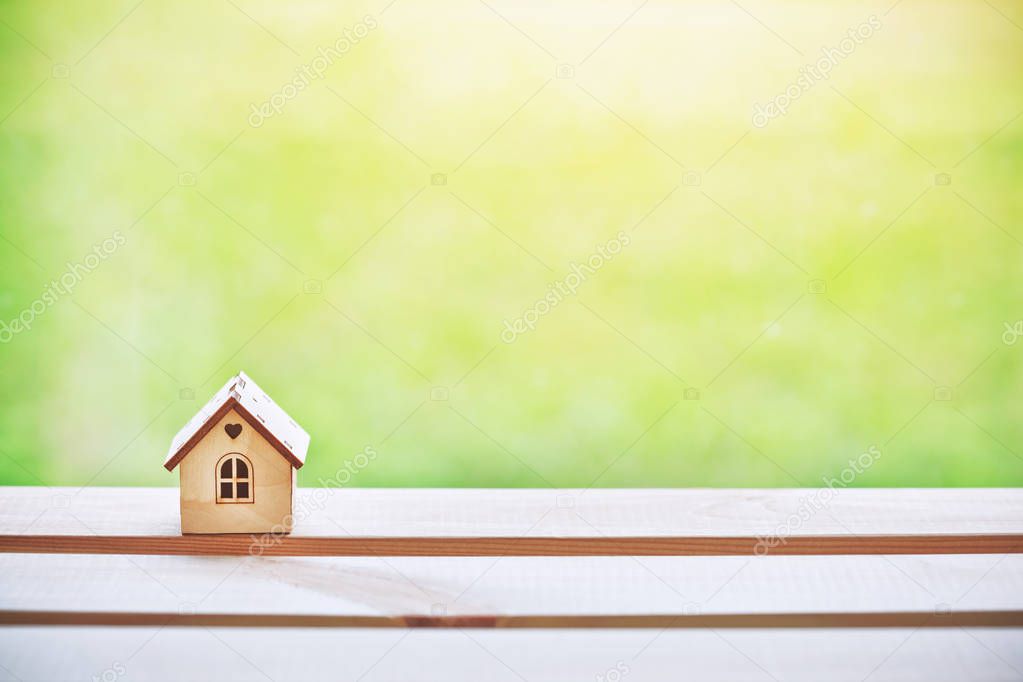 Wooden little house on sunny background. Space for text and logo