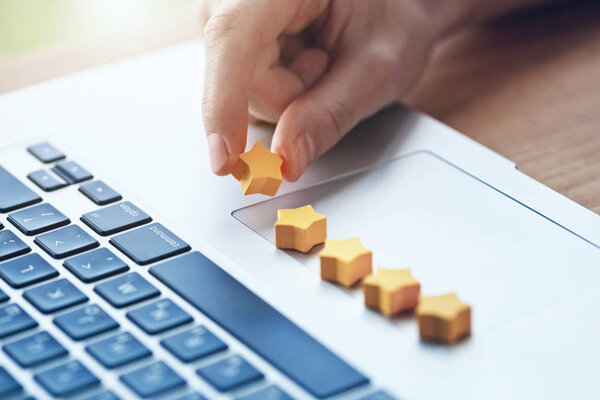 рука дает пятизвездочный рейтинг продукту с ноутбуком
