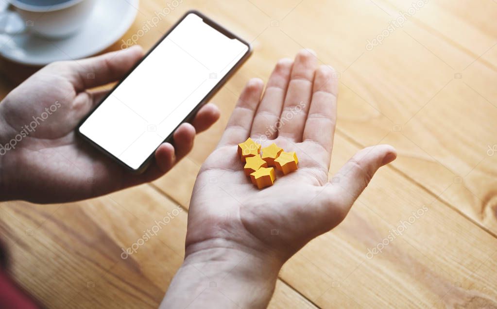 Hand gives five stars rating as product feedback with smart phone