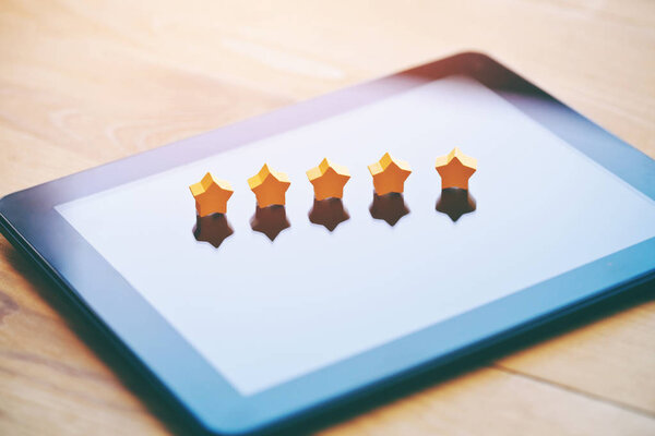 пять звезд рейтинг символ в качестве обратной связи продукта на планшетном компьютере
