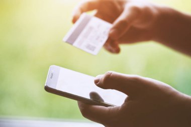 Kredi kartı tutan ve smartphone, online alışveriş kavramı kullanarak eller