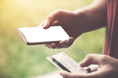 Kredi kartı tutan ve smartphone, online alışveriş kavramı kullanarak eller