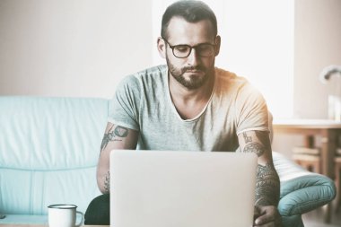 Kahve masasında dizüstü bilgisayarı olan bir adam.