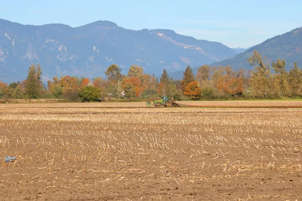 Vista Paisagem Trator Puxando Uma Mangueira Como Agricultor Fertiliza Campo — Fotografia de Stock