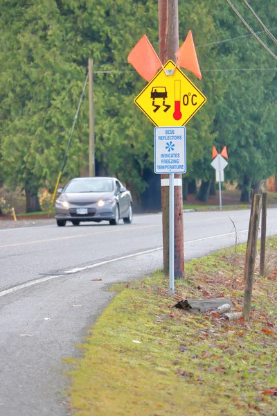 一个特殊的道路安全标志使用视觉辅助 在这种情况下 当温度降到冰点以下 为驾驶人设置危险 湿滑的条件时 就会变成蓝色 — 图库照片