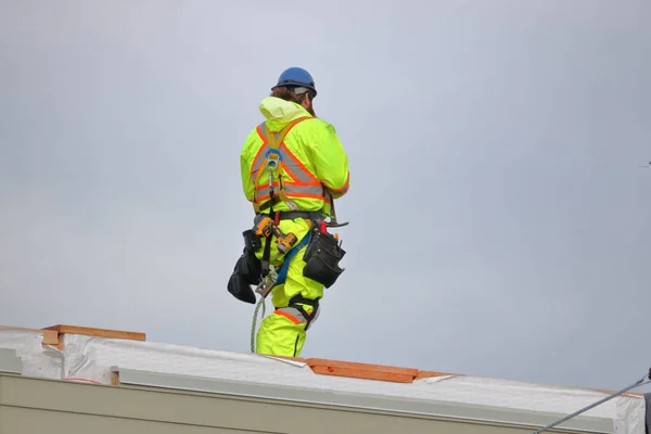 Full body view of a construction worker and his safety reflective apparel and tools.