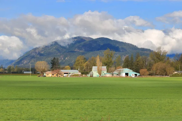 Pastizales Valle Extiende Frente Los Edificios Granja Ubicados Bajo Una — Foto de Stock