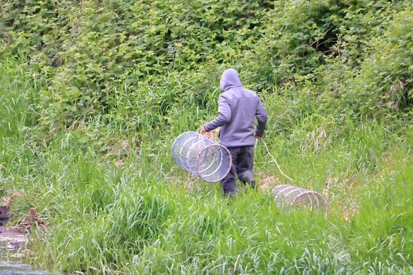 Ein Mann Trägt Krabbennetze Eine Böschung Hinunter Bis Den Rand — Stockfoto