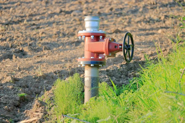 大きな農場のエーカーに水やりに使用される典型的な主な灌漑器具とタップの近くのビュー — ストック写真